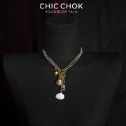 CHICCHOK Shattered Gold Coast naszyjnik z perłą | Ręcznie wykonany letni plażowy choker ze stali nierdzewnej | Luksusowa wakacyjna biżuteria ze złotą muszlą morską i perłą barokową